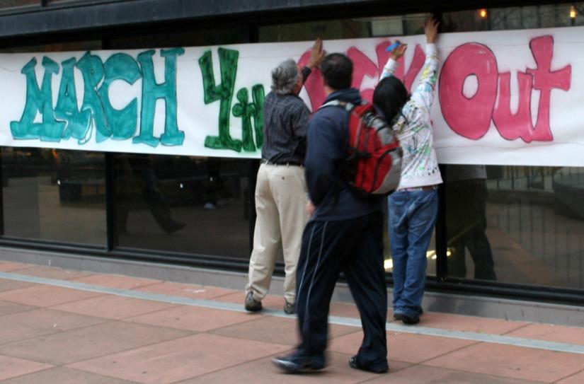 Activists post a banner for the March 4 Day of Action at Laney College in Oakland
